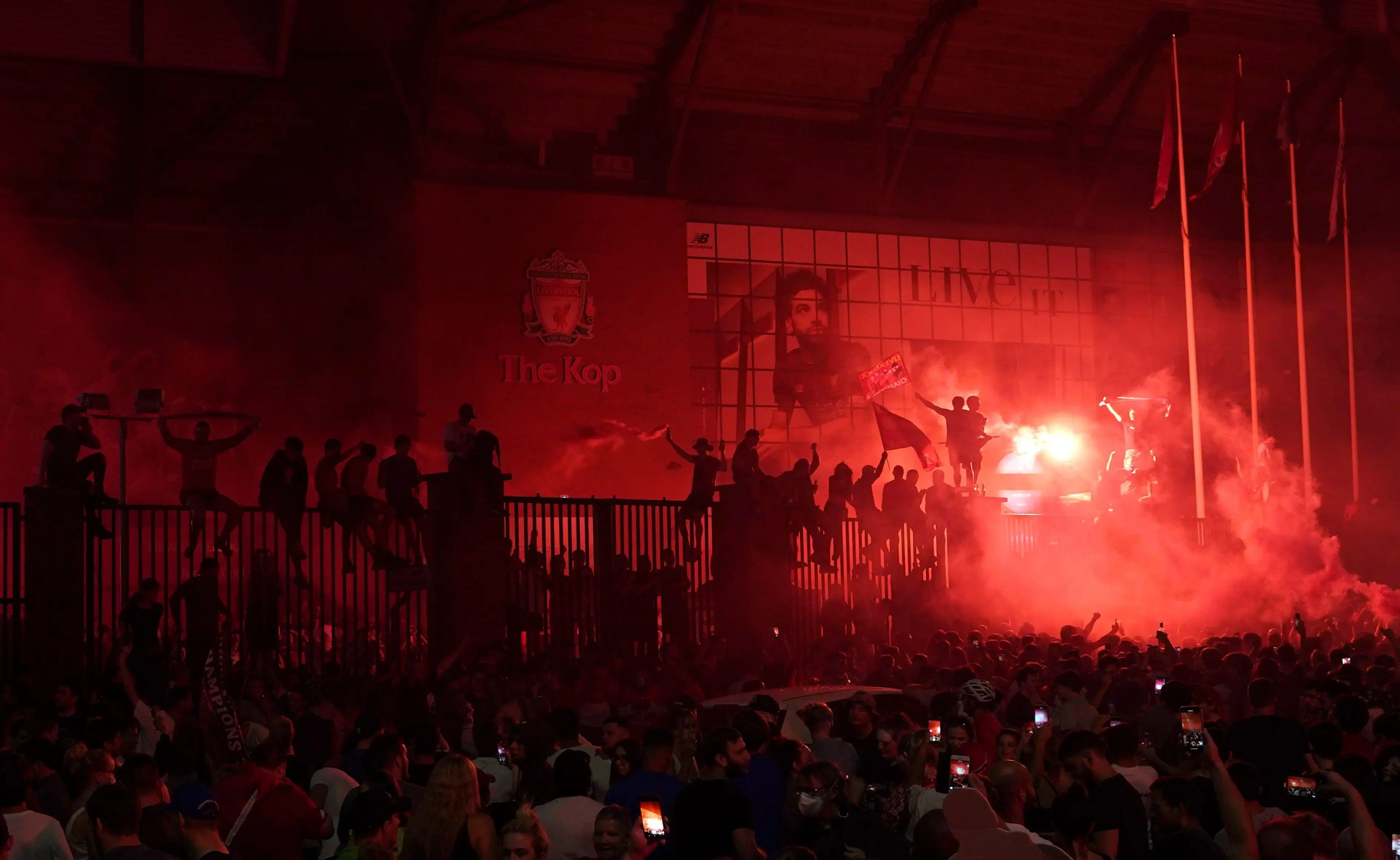 Liverpool supporters celebrate as they gather outside of Anfield Stadium in Liverpool, England, Thursday, June 25, 2020 after Liverpool clinched the English Premier League title. Liverpool took the title after Manchester City failed to beat Chelsea on Wednesday evening